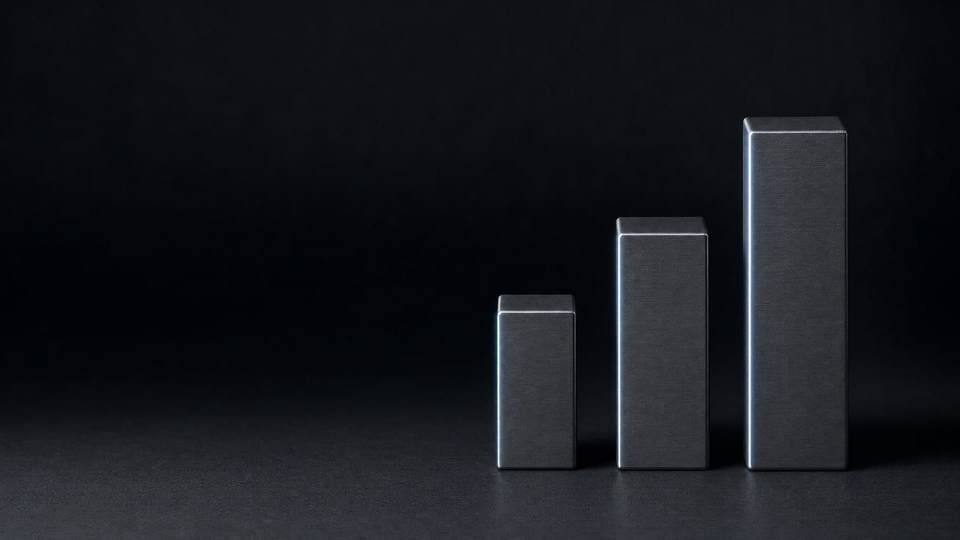 Three machined metal blocks of ascending height standing in an aligned row, representing a three-stage fixed-price engagement ladder